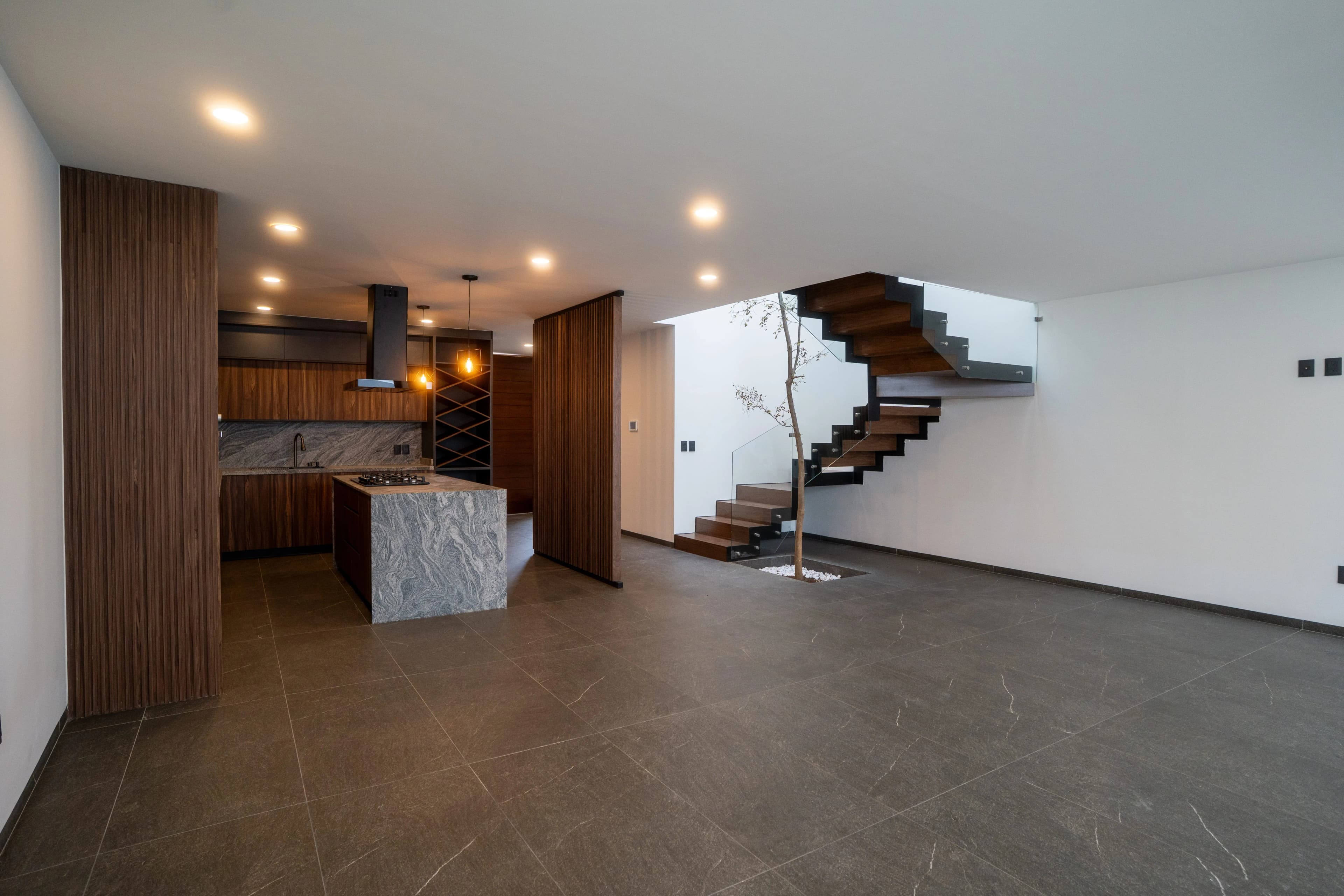 Estancia de Casa Colibrí con cocina de madera y escalera de peldaños volados