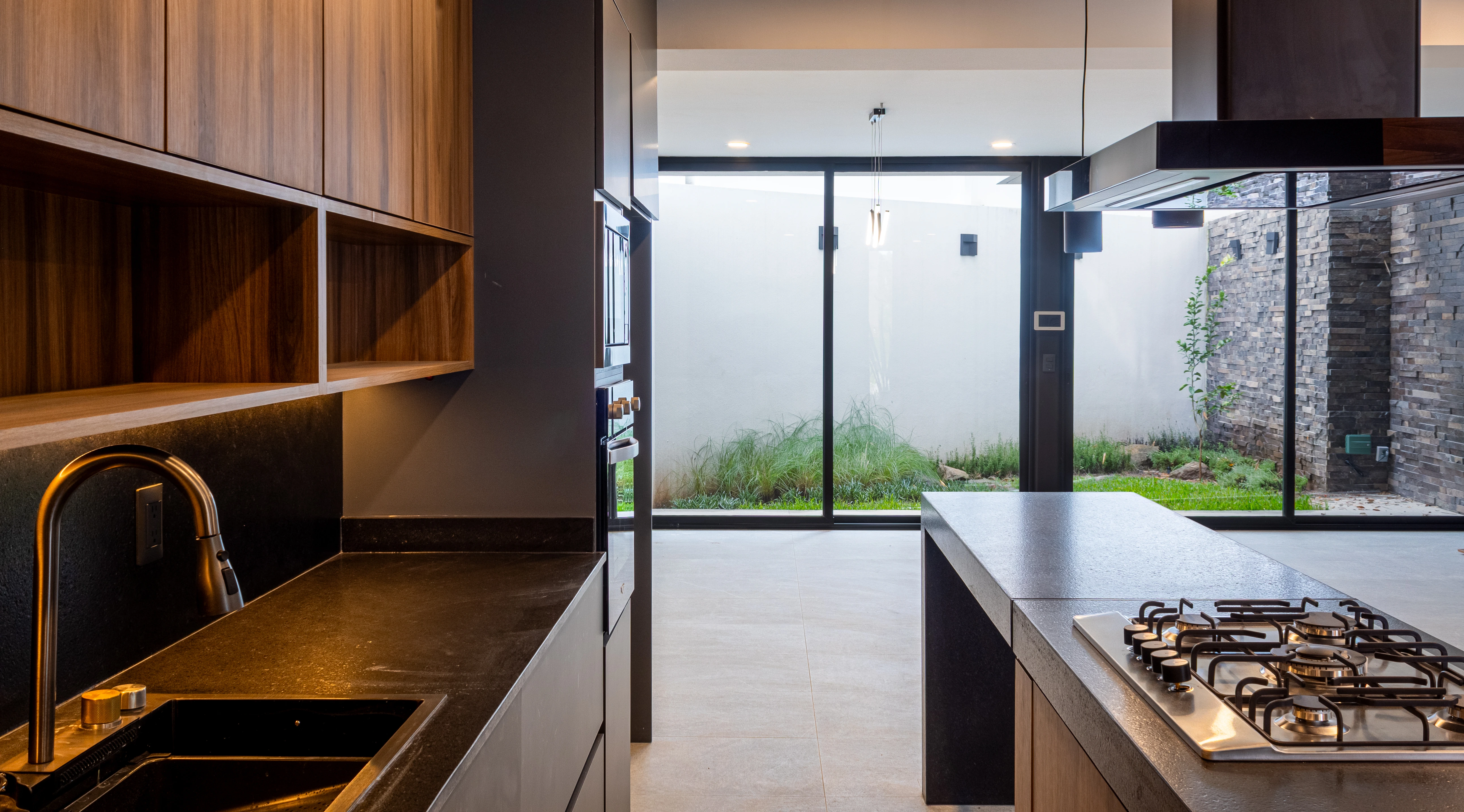 Cocina con concepto abierto y vista al jardín de Casa Encinos en Fraccionamiento Bosque Monarca